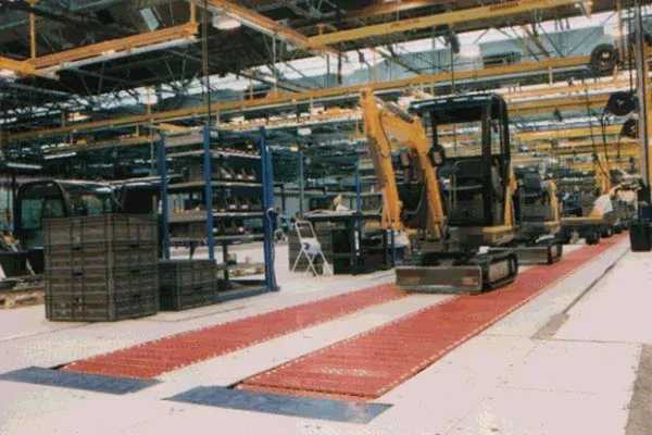 Moldeo por inyección en una cinta transportadora MCM Powertrack 60 Mini Excavators on an Amber Automation HD Slat Conveyors